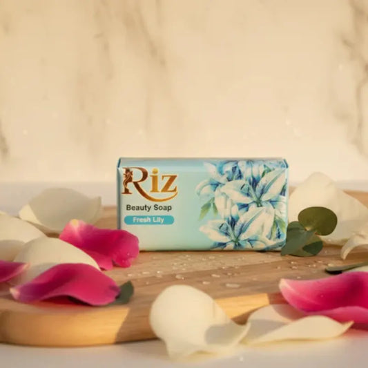 Riz Fresh Lily beauty soap bar on a wooden tray with flower petals.